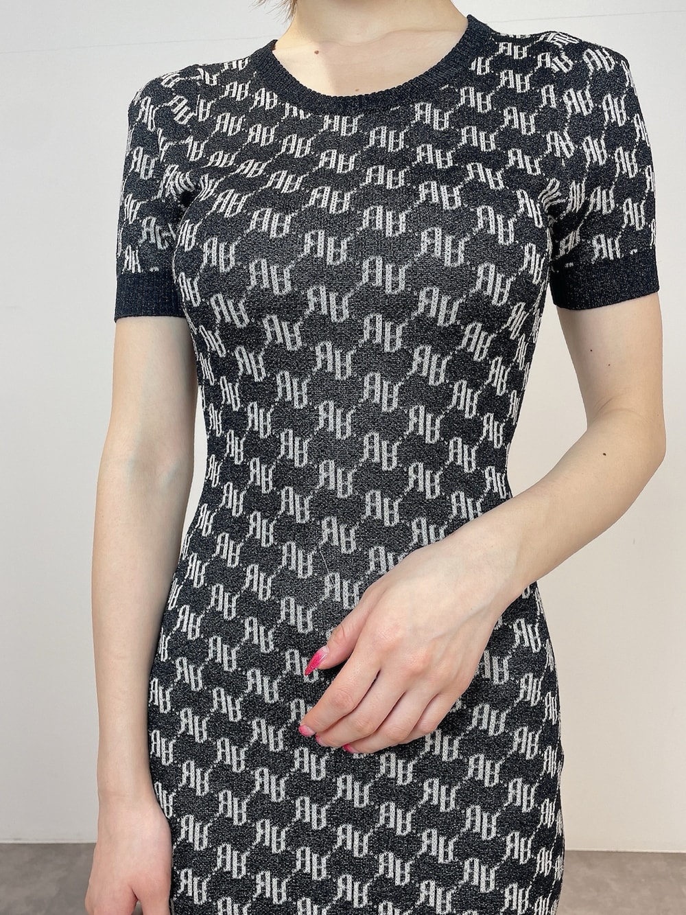 ホワイト系のハンドバッグ、ホワイト系のサンダル、ブラック系のワンピースを着用したレディースの春コーディネートの5枚目の写真