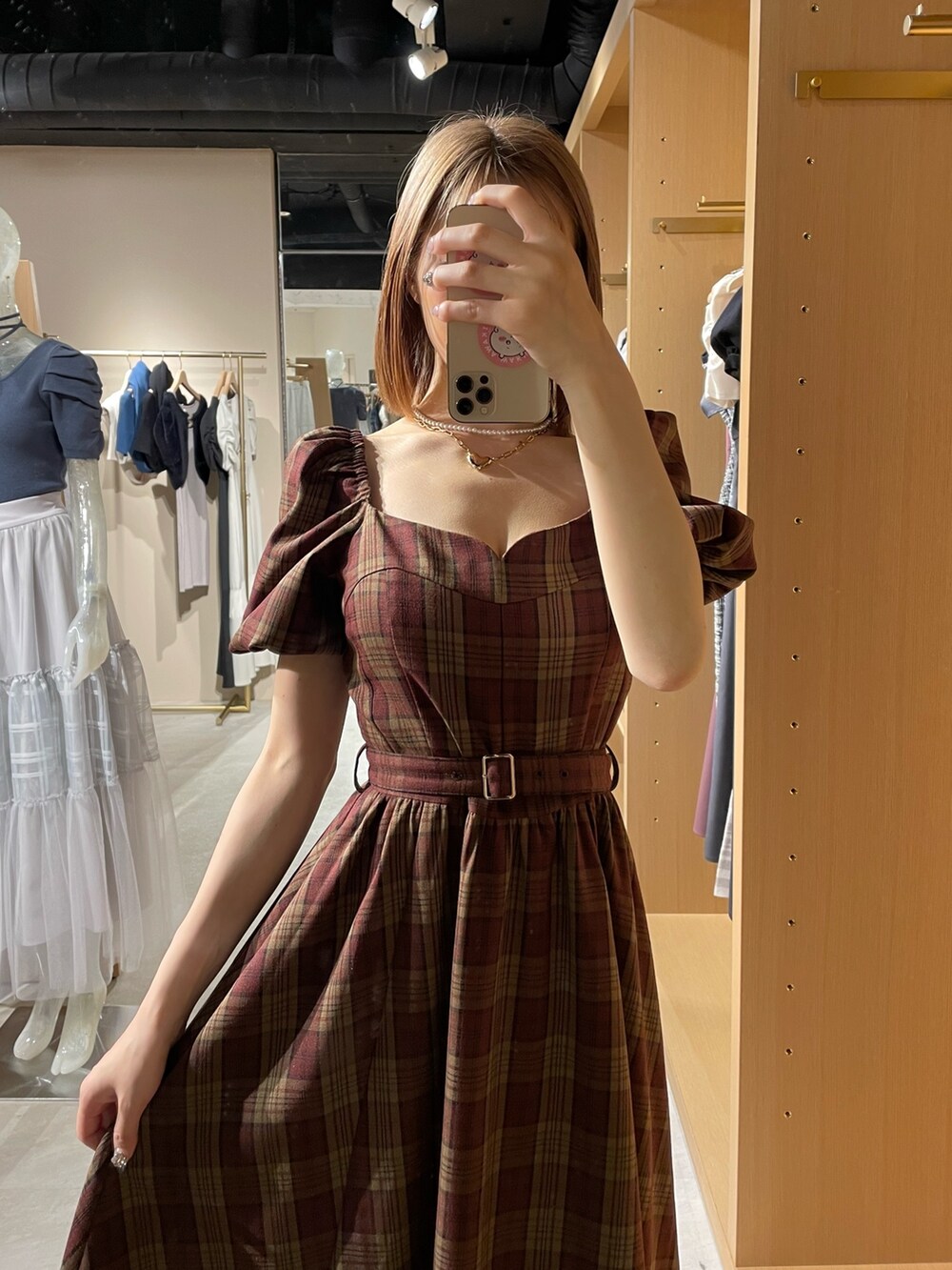 レッド系のワンピース、ブラック系のパンプス、ゴールド系のネックレスを着用したレディースの夏コーディネートの7枚目の写真