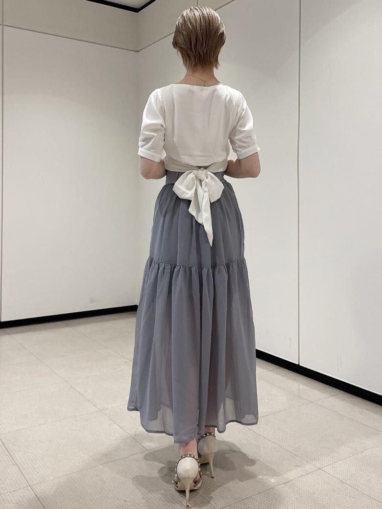 ホワイト系のパンプス、ホワイト系のシャツ/ブラウス、ブルー系のスカートを着用したレディースの夏コーディネートの3枚目の写真