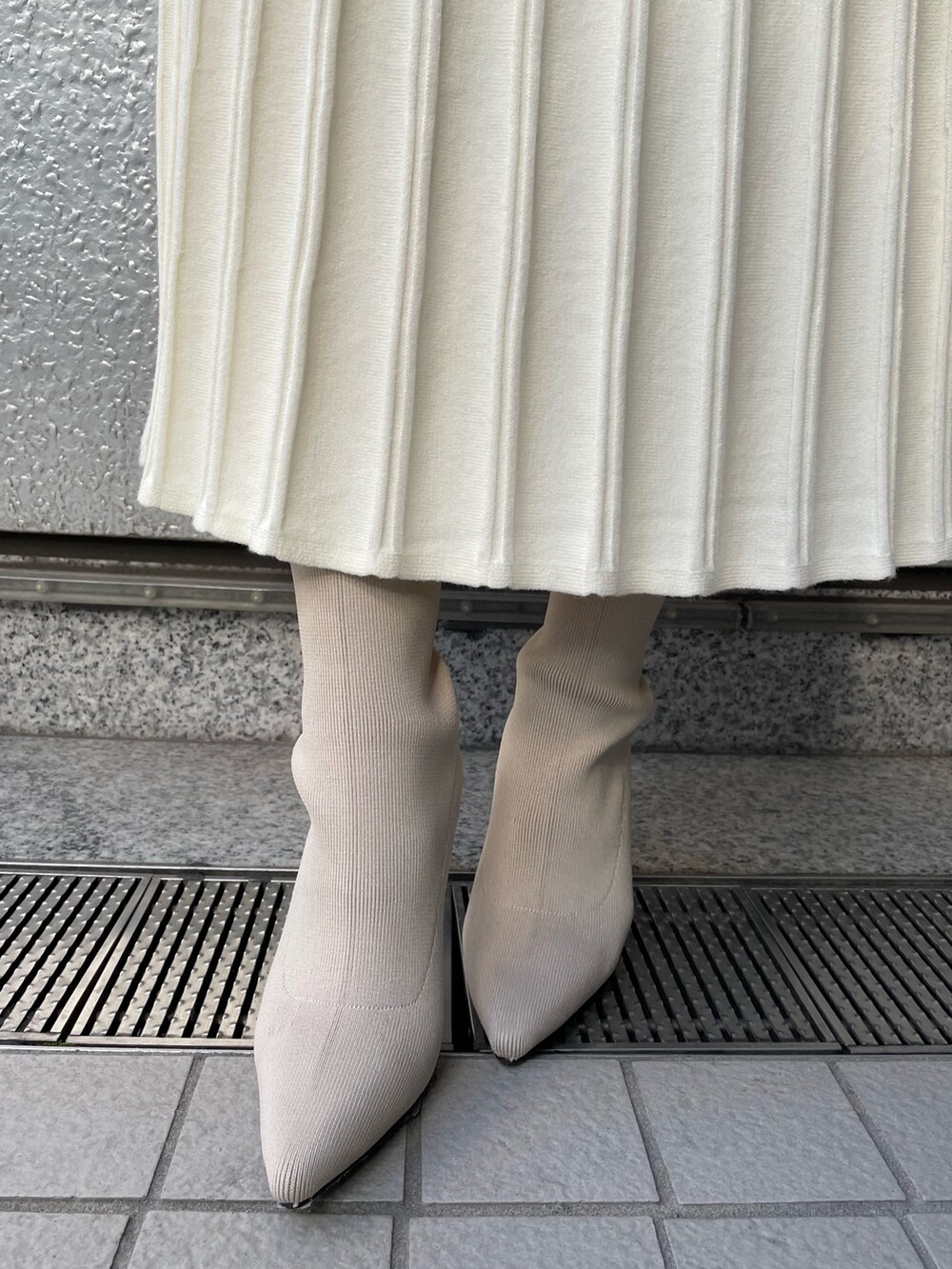 ホワイト系のワンピース、ホワイト系のブーツ、ホワイト系のブルゾンを着用したレディースの冬コーディネートの4枚目の写真