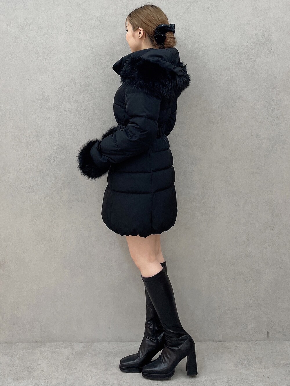 ブラック系のダウンジャケット/コート、ブラック系のニット/セーター、ブラック系のスカートを着用したレディースの夏コーディネートの3枚目の写真