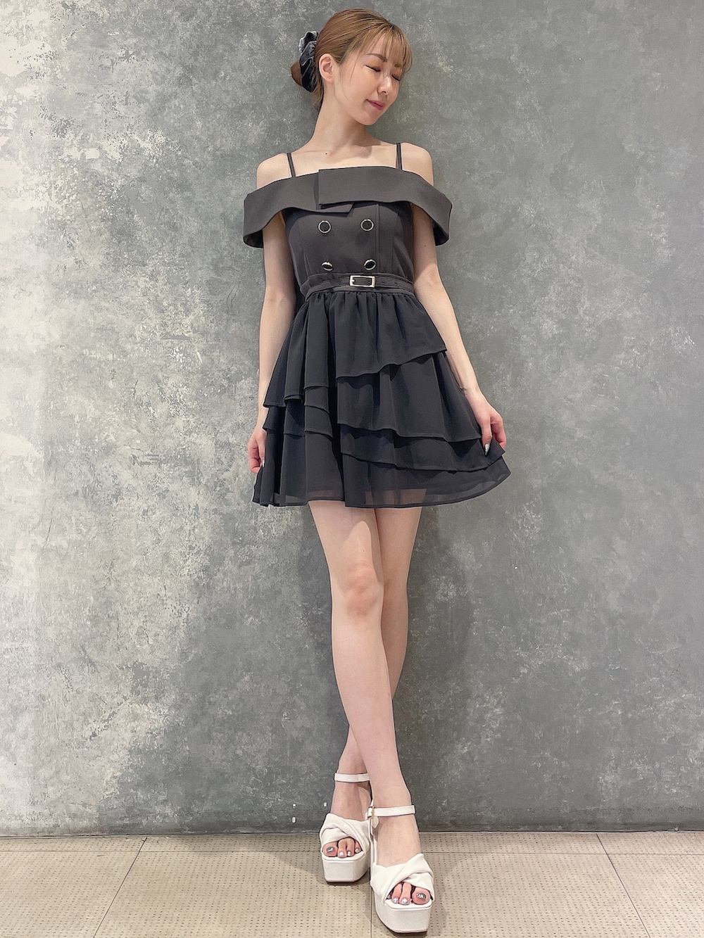 グレー系のワンピース、ホワイト系のサンダル、グレー系のシュシュを着用したレディースの夏コーディネートの4枚目の写真