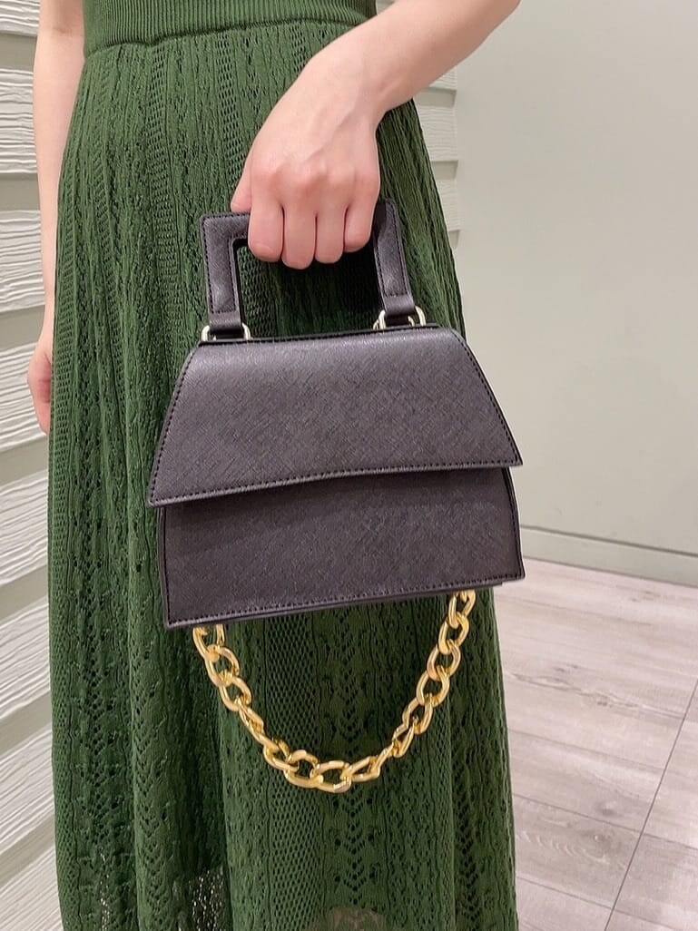ブラック系のパンプス、ブラック系のショルダーバッグ、グリーン系のワンピースを着用したレディースの春コーディネートの8枚目の写真