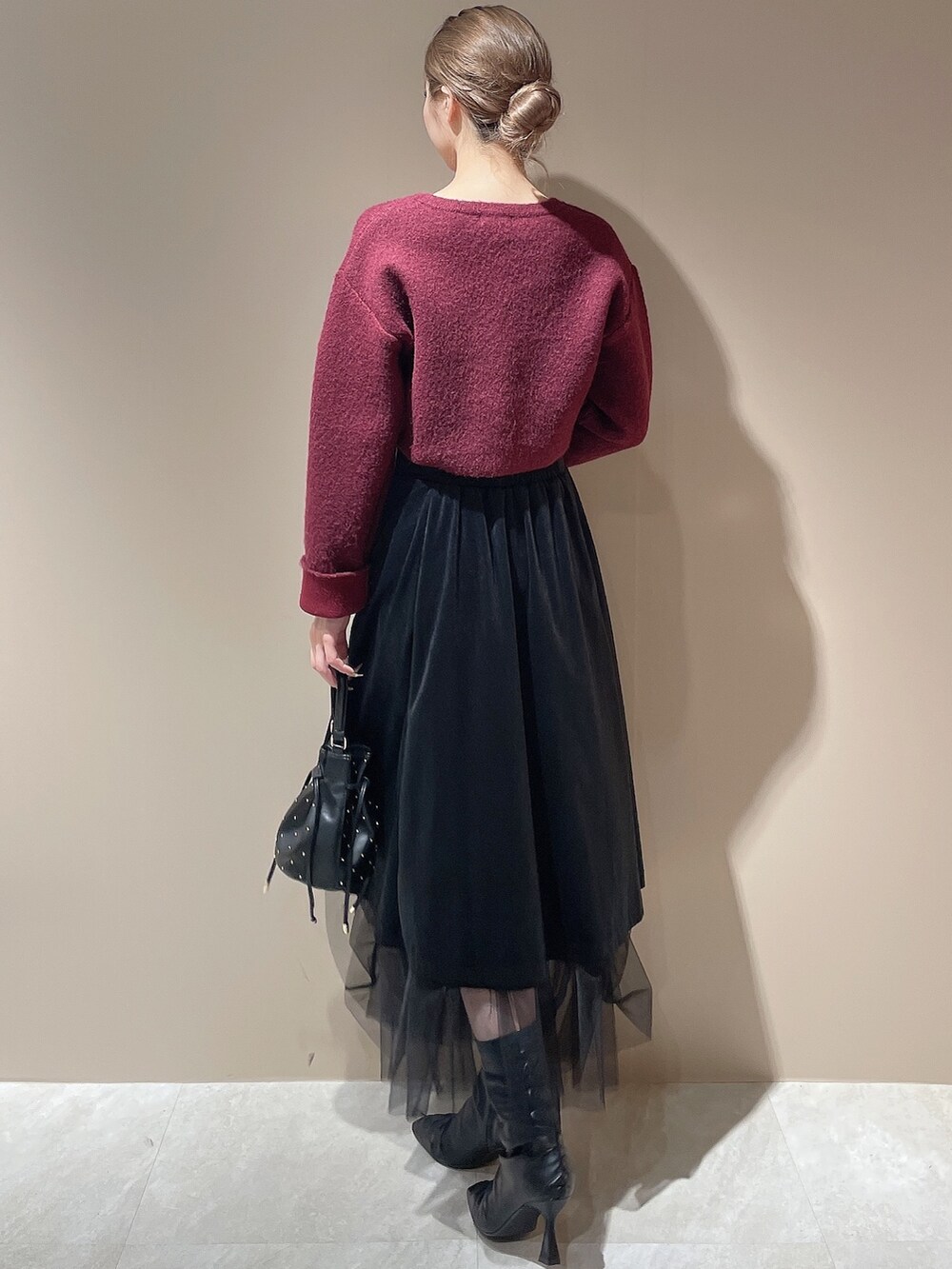 ブラック系のブーツ、レッド系のカーディガン/ボレロ、ブラック系のハンドバッグを着用したレディースの秋コーディネートの5枚目の写真