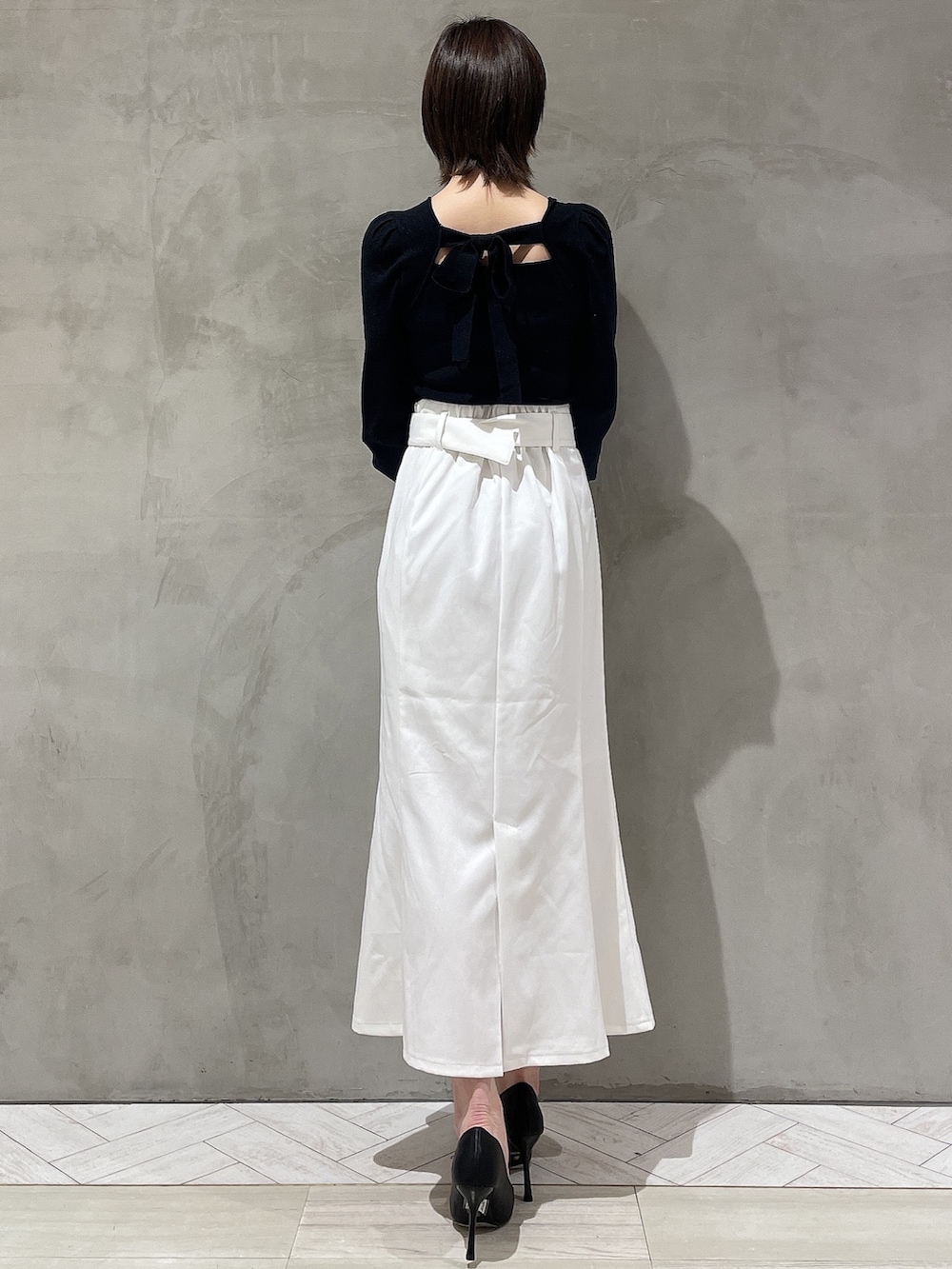 ブラック系のパンプス、ブラック系のニット/セーター、ホワイト系のデニムジャケットを着用したレディースの冬コーディネートの7枚目の写真