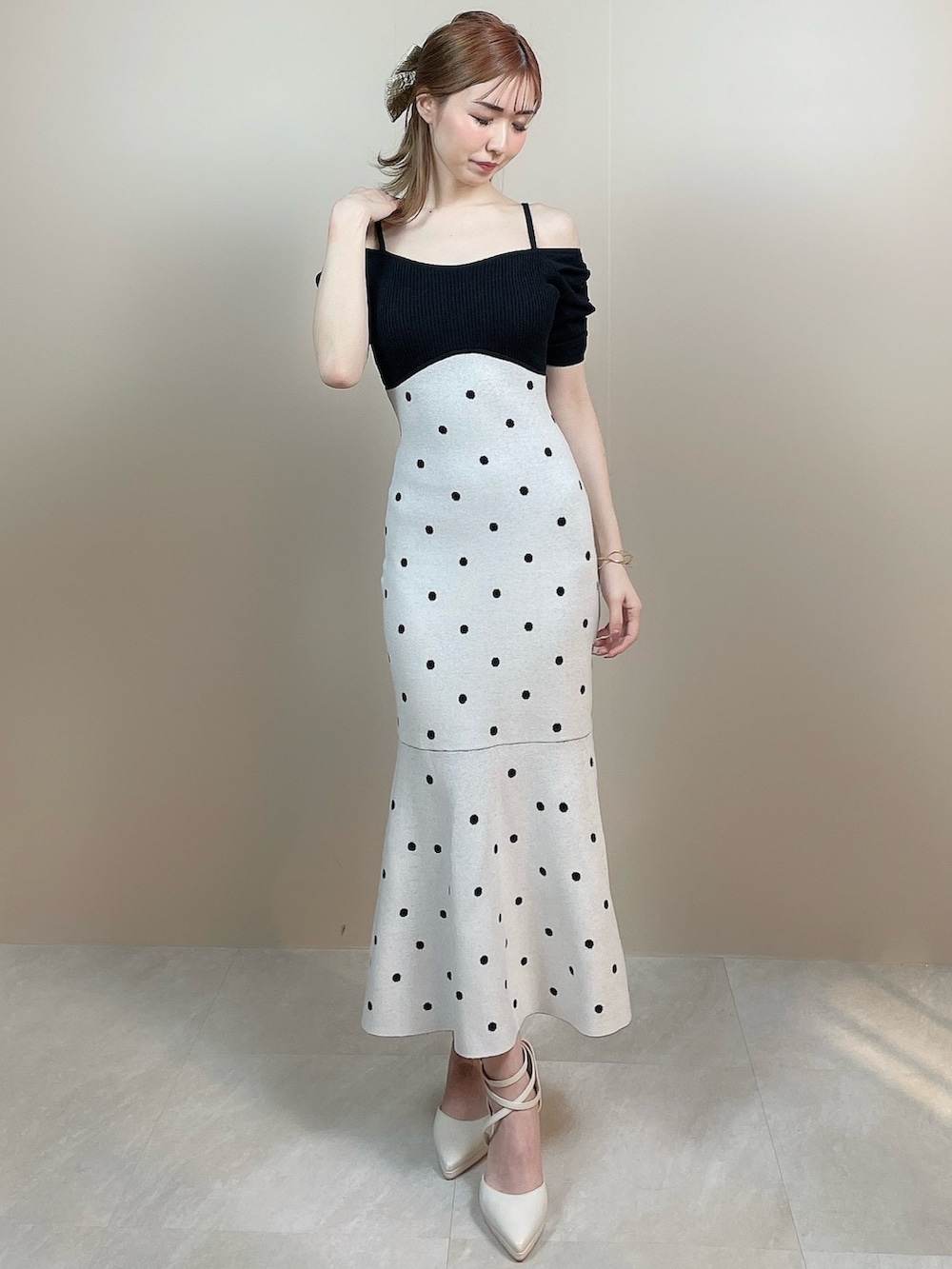 ブラック系のワンピース、ホワイト系のパンプスを着用したレディースの冬コーディネートの2枚目の写真