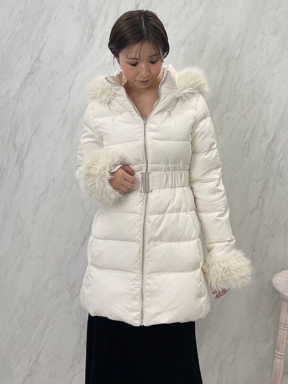 ブラック系のブーツ、ブラック系のワンピース、ホワイト系のダウンジャケット/コートを着用したレディースの夏コーディネートの6枚目の写真