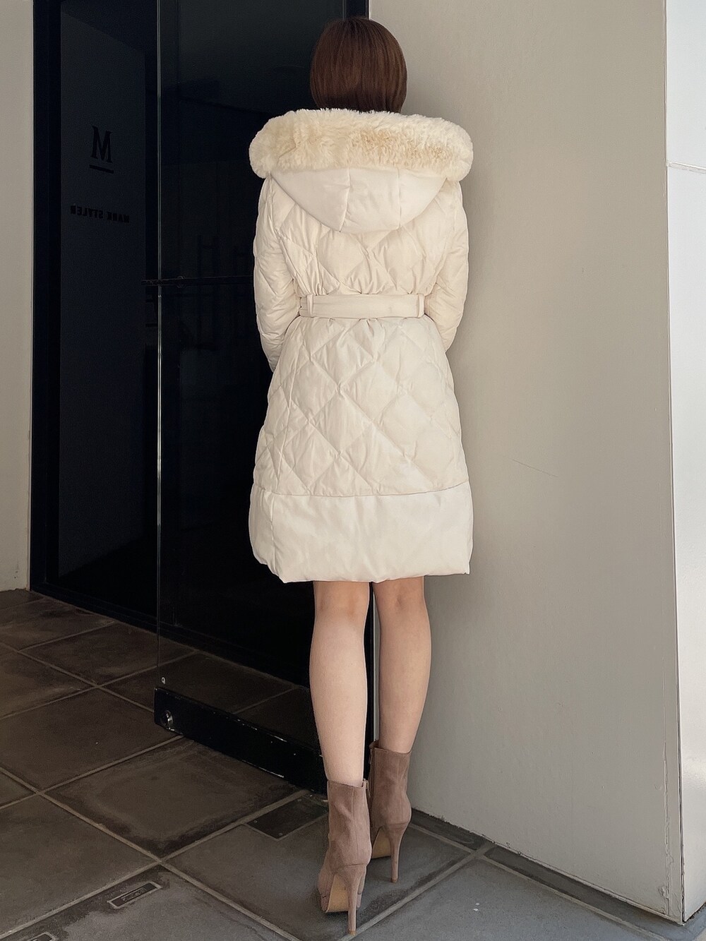 ベージュ系のブーツ、ホワイト系のダウンジャケット/コートを着用したレディースの夏コーディネートの5枚目の写真