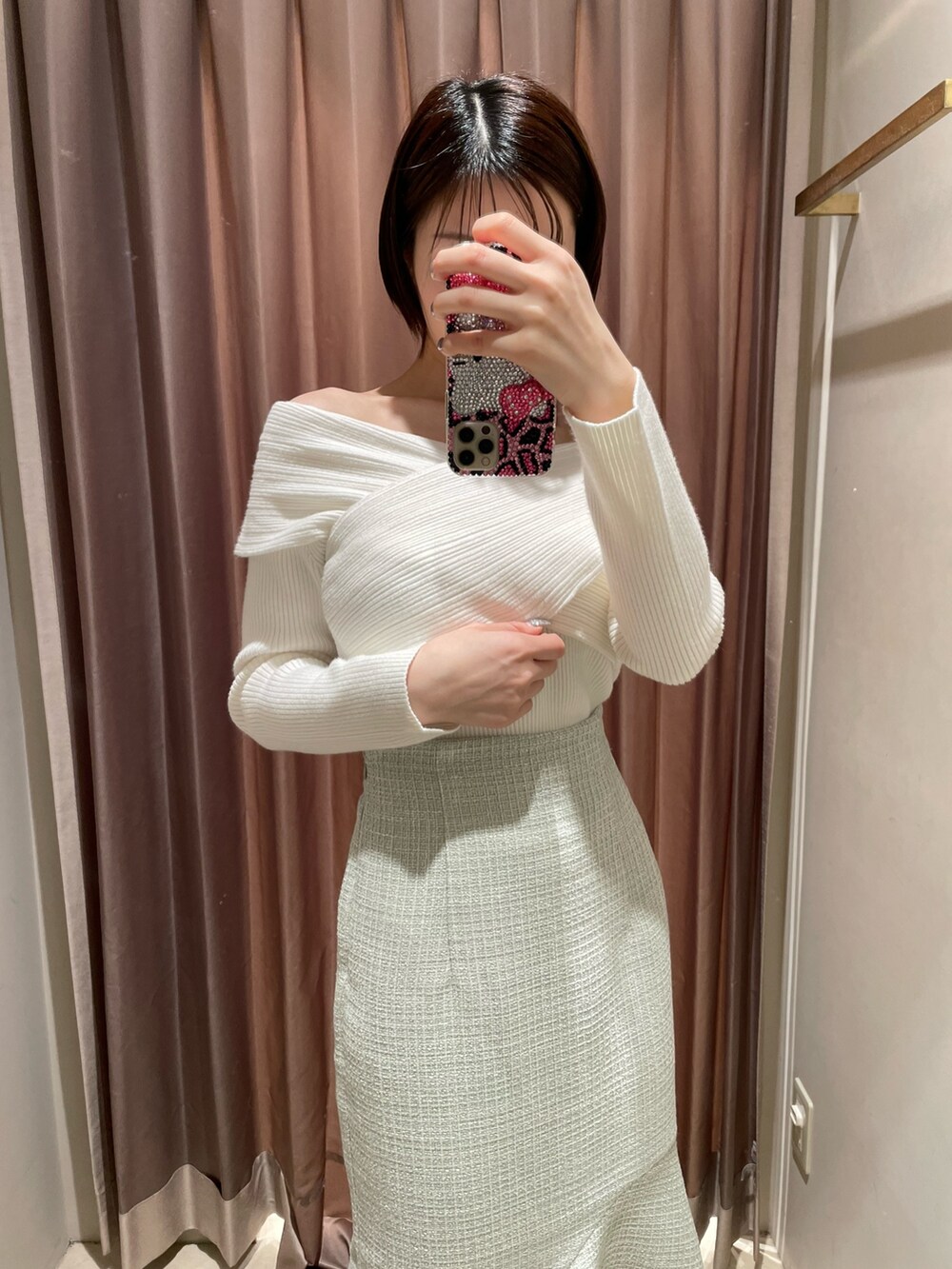 ホワイト系のニット/セーター、グリーン系のスカート、ブラック系のブーツを着用したレディースの冬コーディネートの3枚目の写真