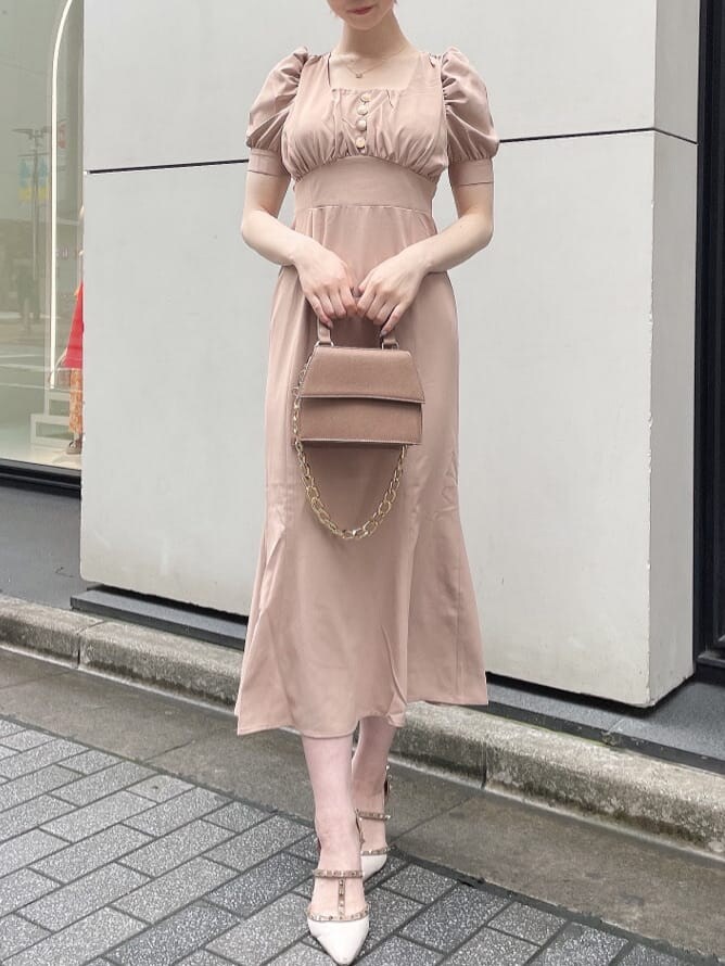 ホワイト系のパンプス、ブラウン系のショルダーバッグ、ピンク系のワンピースを着用したレディースの夏コーディネートの2枚目の写真