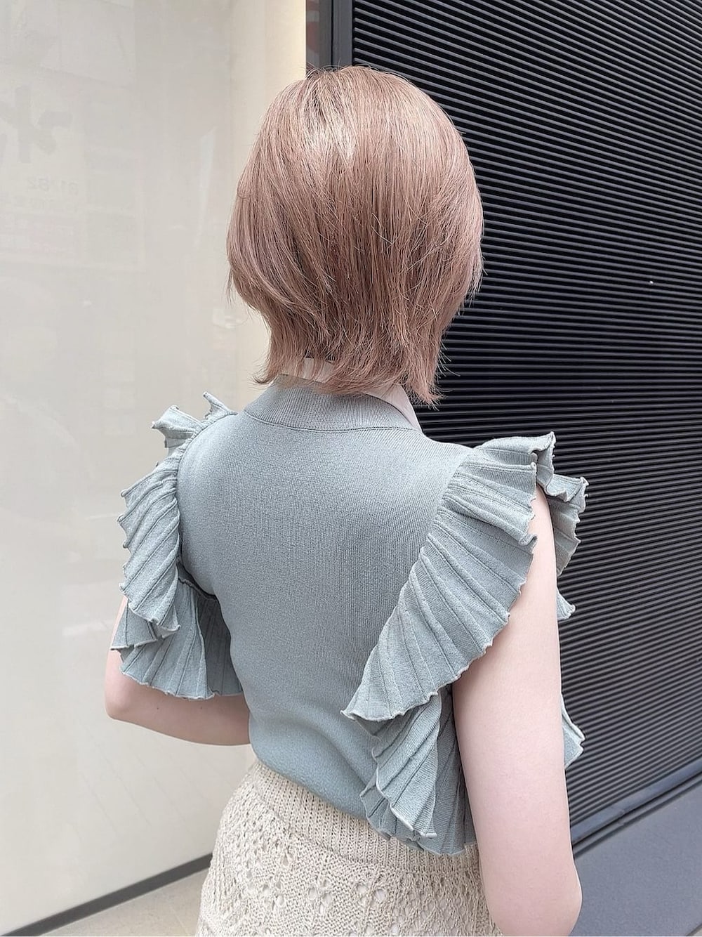 ベージュ系のスカート、ホワイト系のサンダル、グリーン系のニット/セーターを着用したレディースの春コーディネートの7枚目の写真