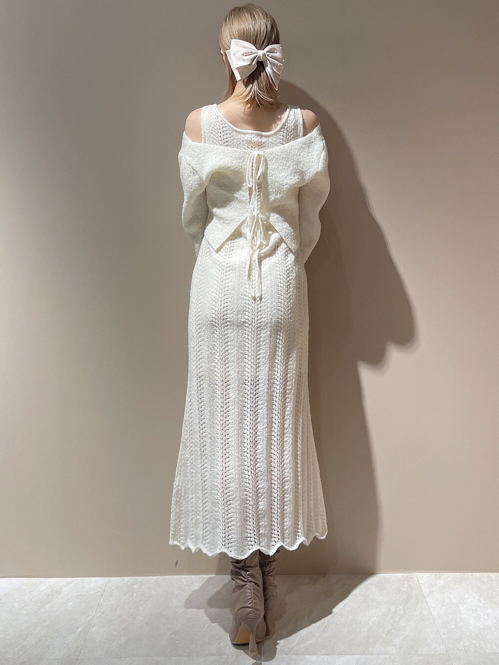 ベージュ系のブーツ、ベージュ系のダウンジャケット/コート、ホワイト系のワンピースを着用したレディースの秋コーディネートの8枚目の写真