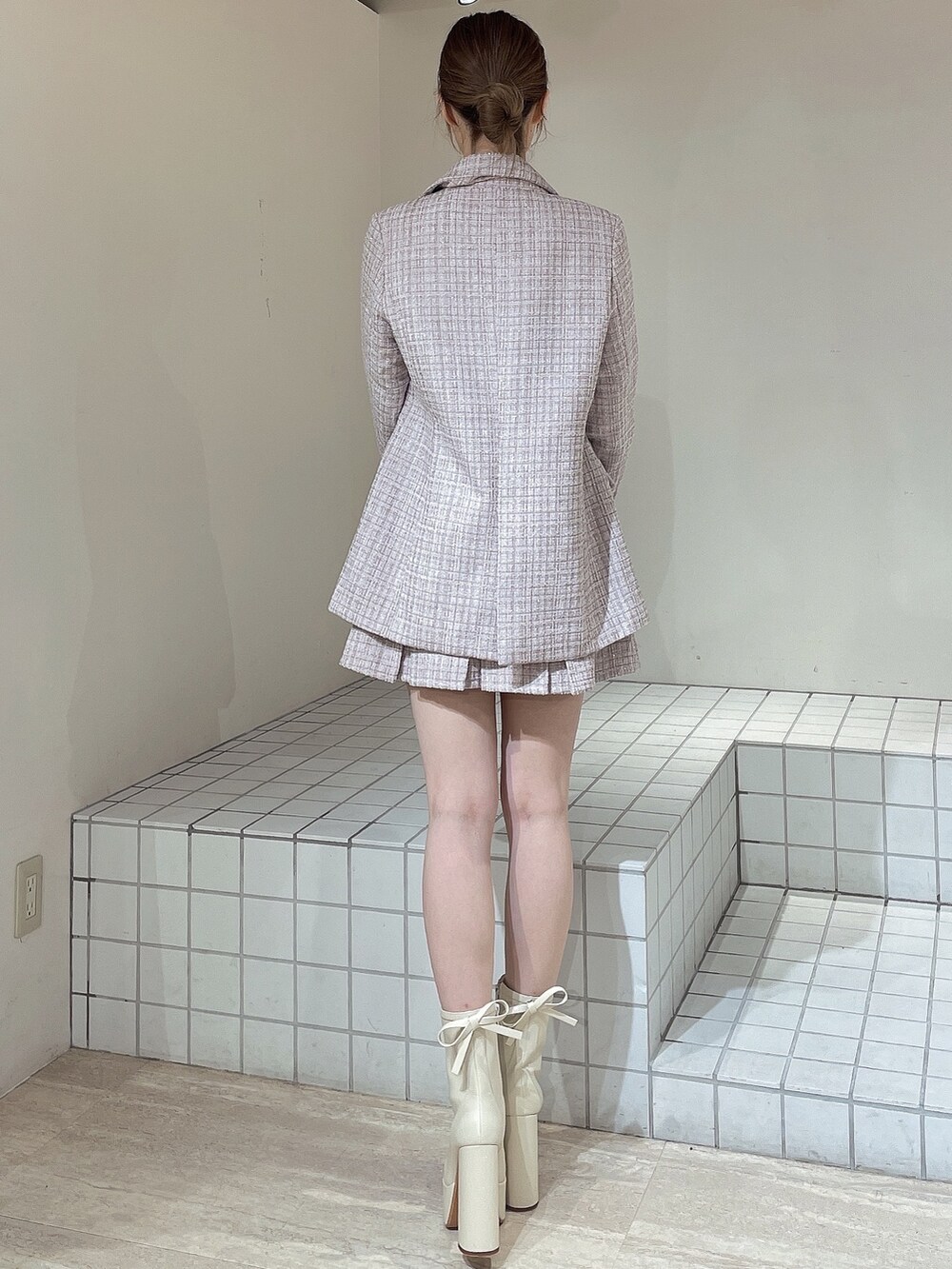ピンク系のその他アウター、ピンク系のスカート、ホワイト系のニット/セーターを着用したレディースの冬コーディネートの4枚目の写真