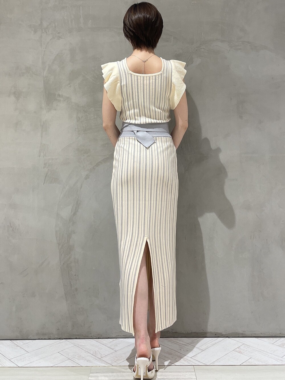 ホワイト系のパンプス、ホワイト系のワンピースを着用したレディースの春コーディネートの3枚目の写真