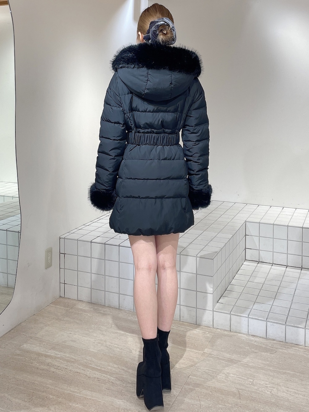 ブラック系のダウンジャケット/コート、ブラック系のワンピース、ブラック系のブーツを着用したレディースの秋コーディネートの4枚目の写真