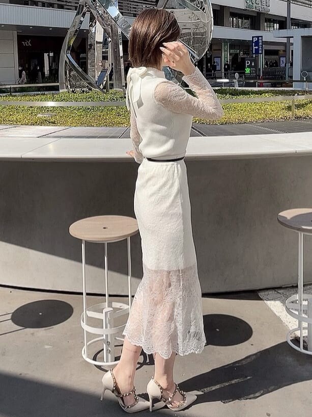 ホワイト系のスカート、ホワイト系のパンプス、ホワイト系のニット/セーターを着用したレディースの春コーディネートの2枚目の写真