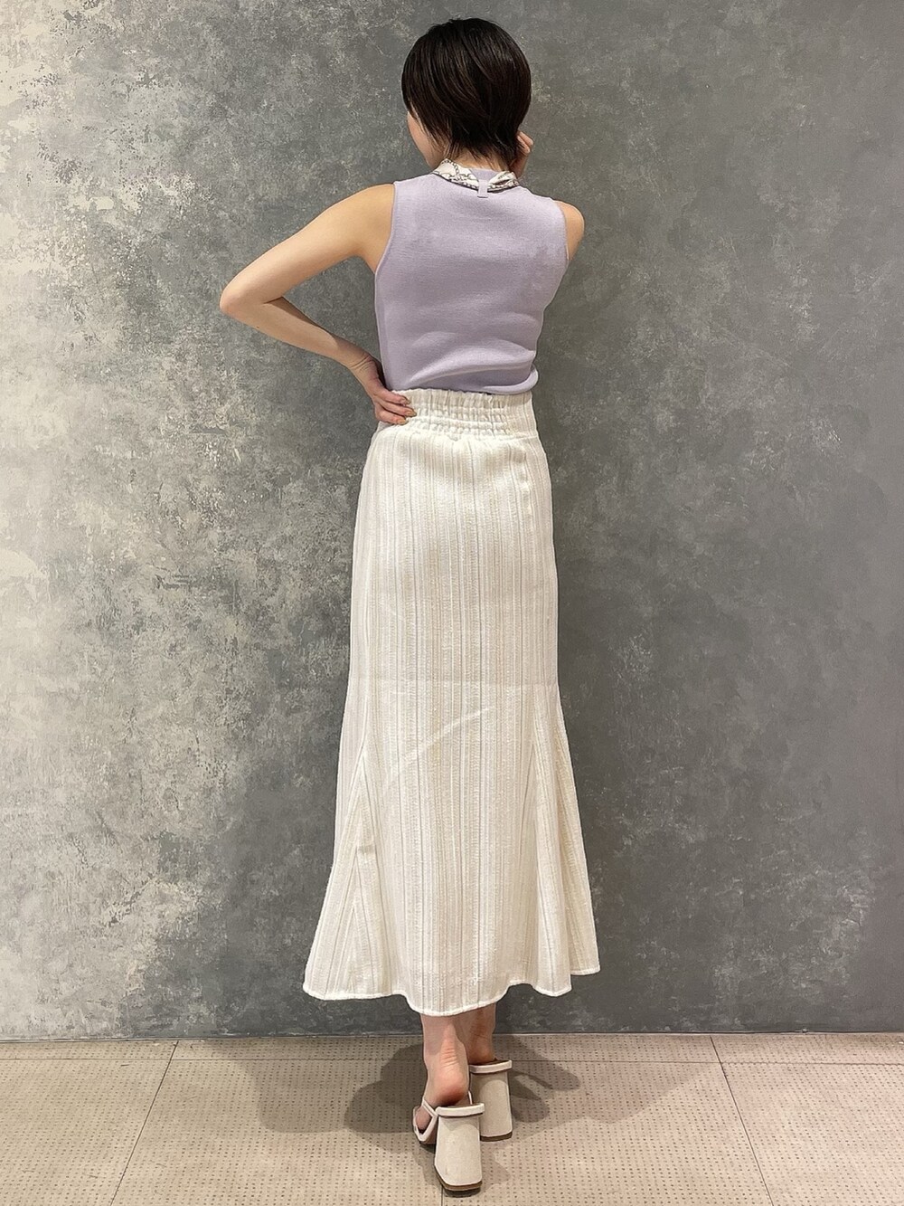 ホワイト系のサンダル、ホワイト系のスカート、パープル系のタンクトップを着用したレディースの夏コーディネートの3枚目の写真