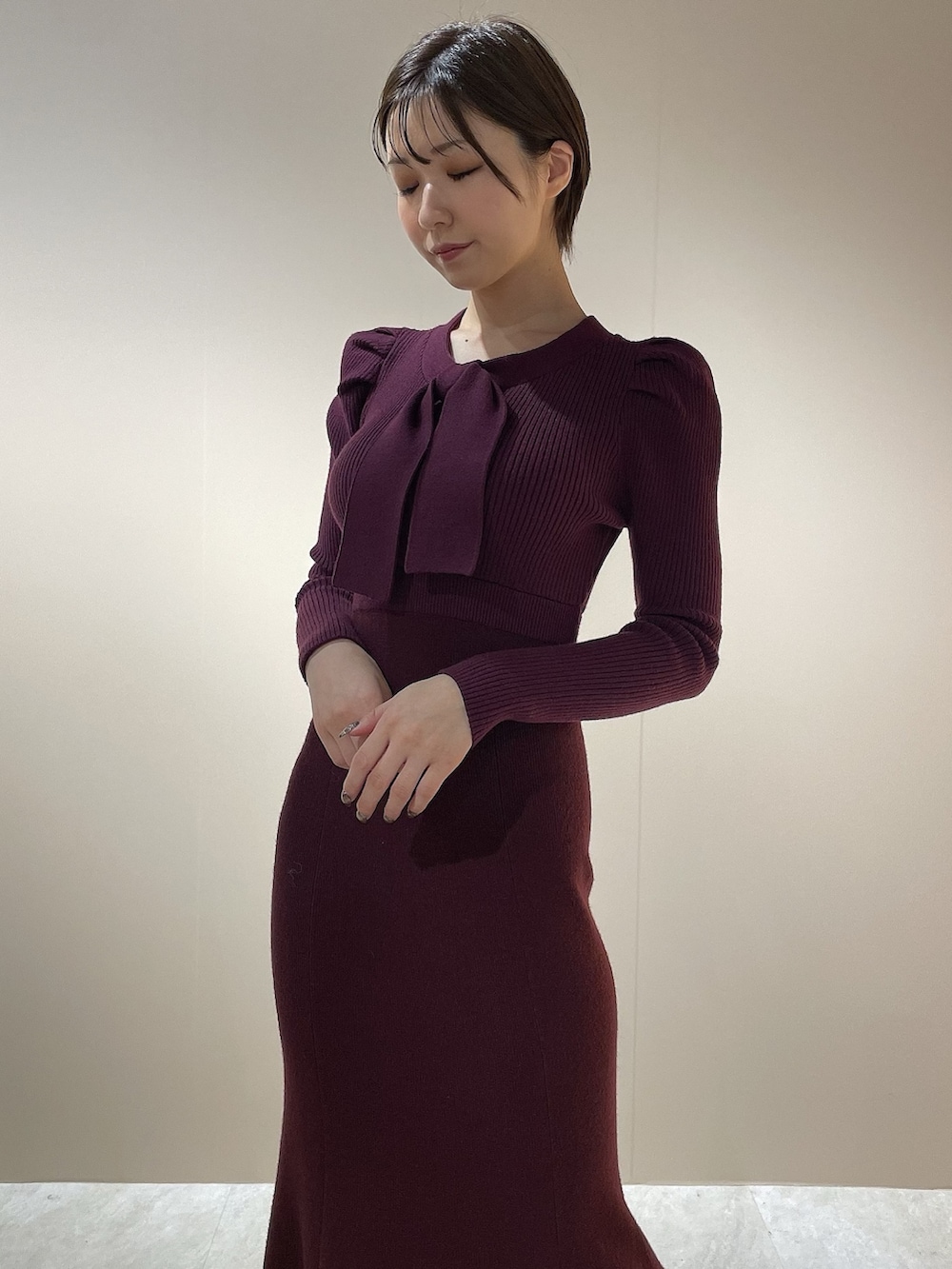 レッド系のワンピース、ブラック系のパンプスを着用したレディースの秋コーディネートの6枚目の写真