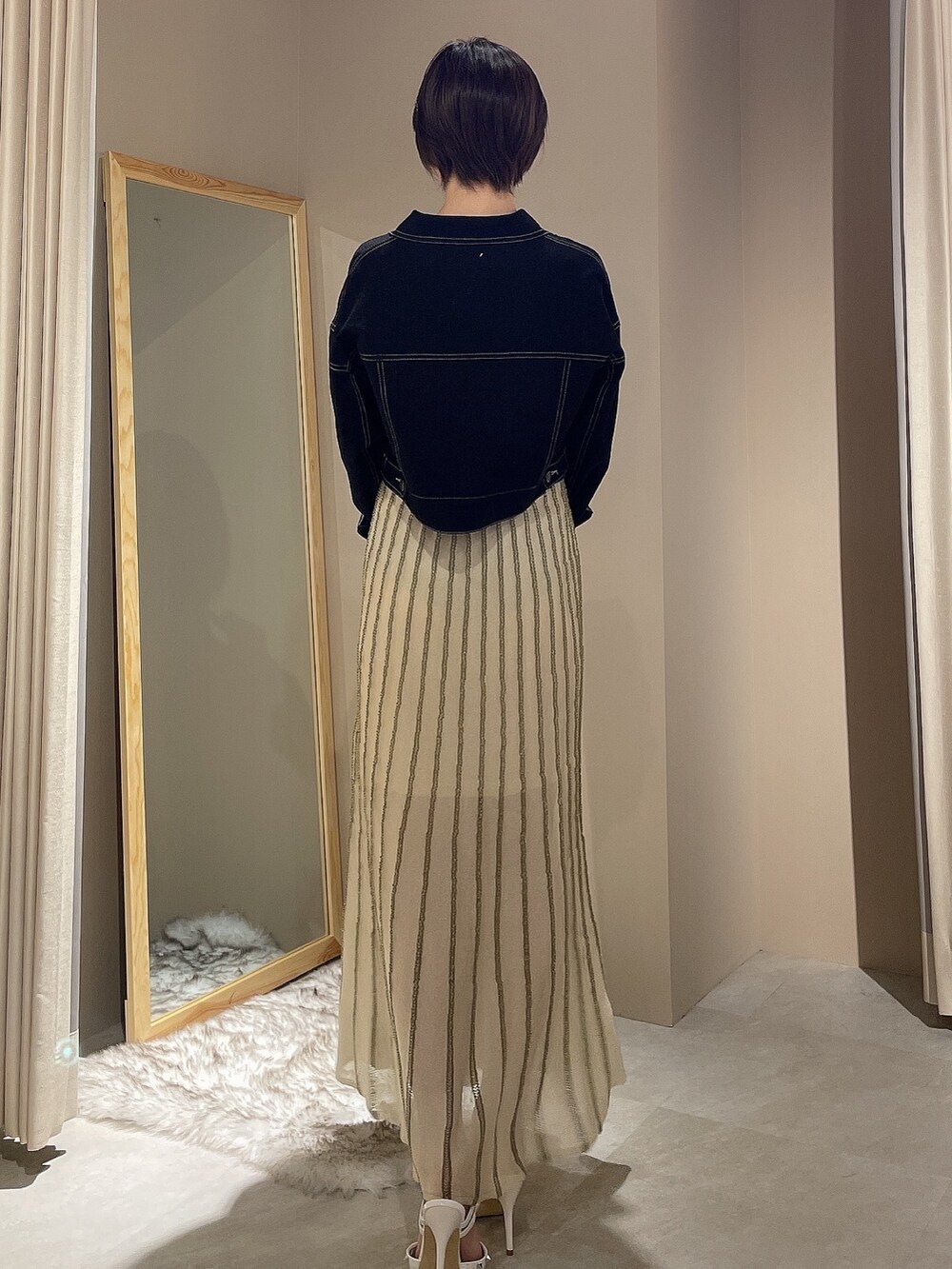 ホワイト系のワンピース、ブラック系のデニムジャケットを着用したレディースの春コーディネートの3枚目の写真