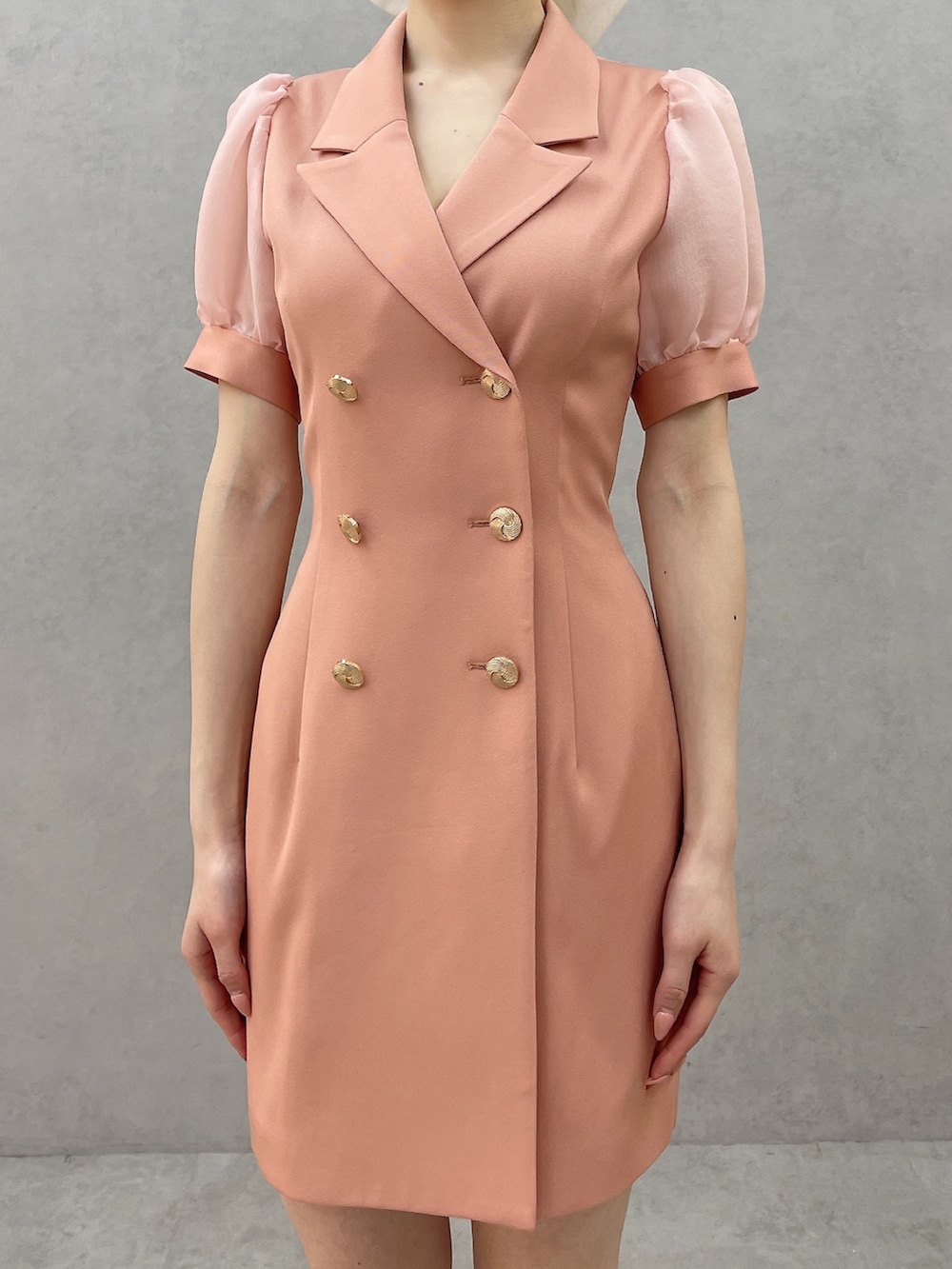 オレンジ系のワンピース、ホワイト系のブーツ、ホワイト系のバレッタ/ヘアクリップを着用したレディースの春コーディネートの5枚目の写真