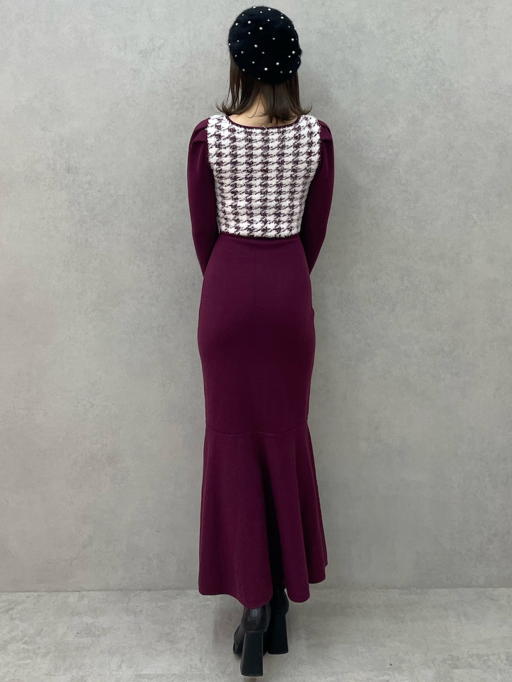 レッド系のワンピース、ブラック系のブーツ、ブラック系のハンチング/ベレー帽を着用したレディースの秋コーディネートの3枚目の写真