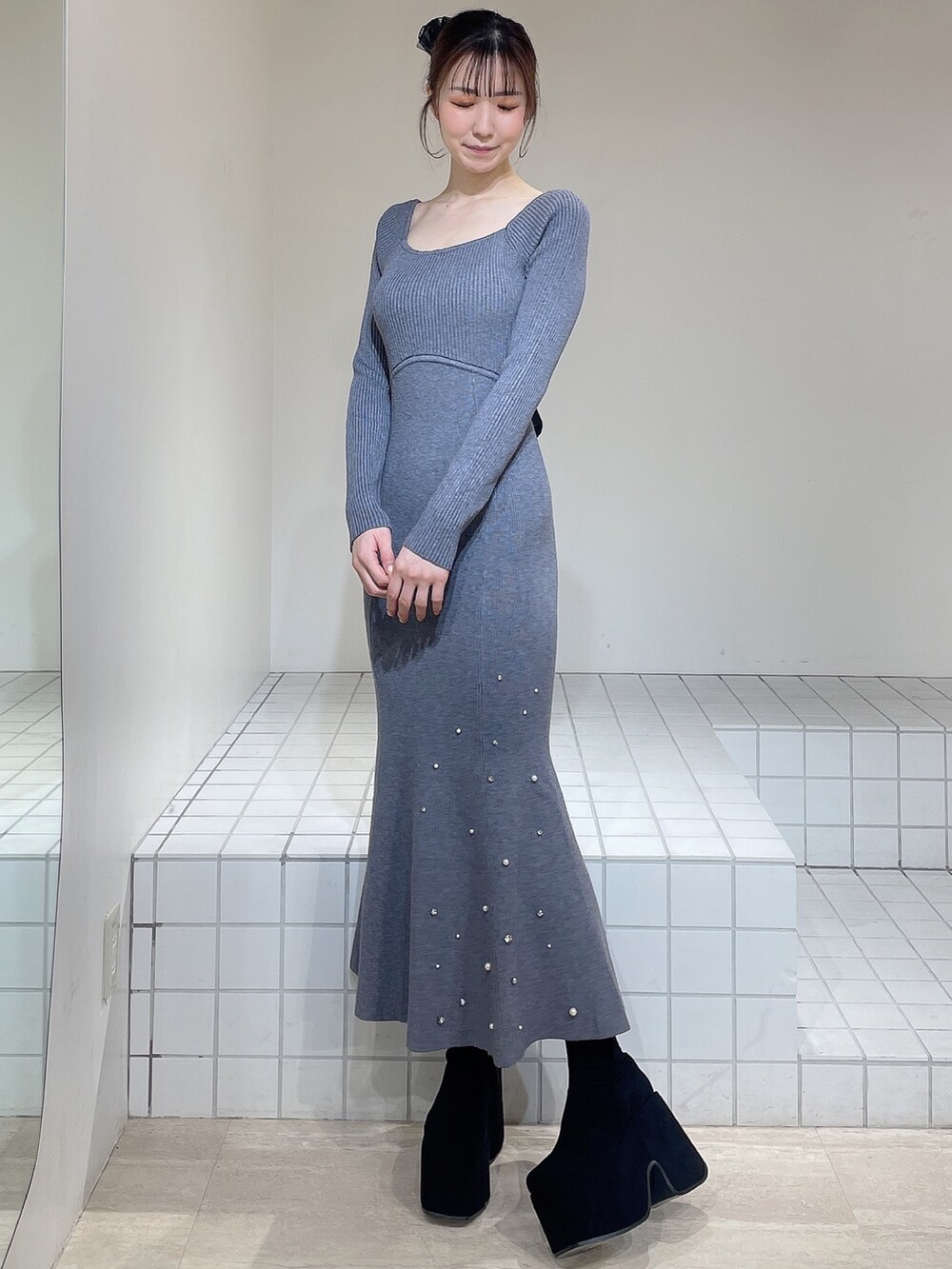 グレー系のワンピース、ブラック系のブーツ、ブラック系のバレッタ/ヘアクリップを着用したレディースの冬コーディネートの3枚目の写真