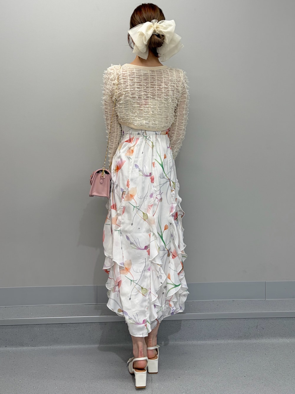 ホワイト系のワンピース、ピンク系のショルダーバッグ、ホワイト系のパンプスを着用したレディースの冬コーディネートの3枚目の写真