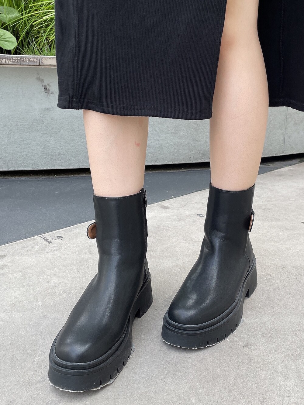 ブラック系のワンピース、ブラック系のブーツを着用したレディースの秋コーディネートの7枚目の写真