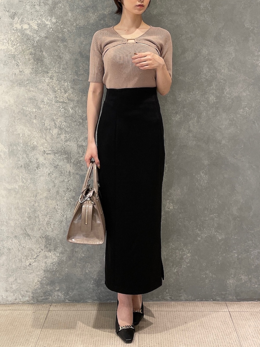 ブラック系のサンダル、ベージュ系のニット/セーター、ブラック系のスカートを着用したレディースの夏コーディネートの2枚目の写真