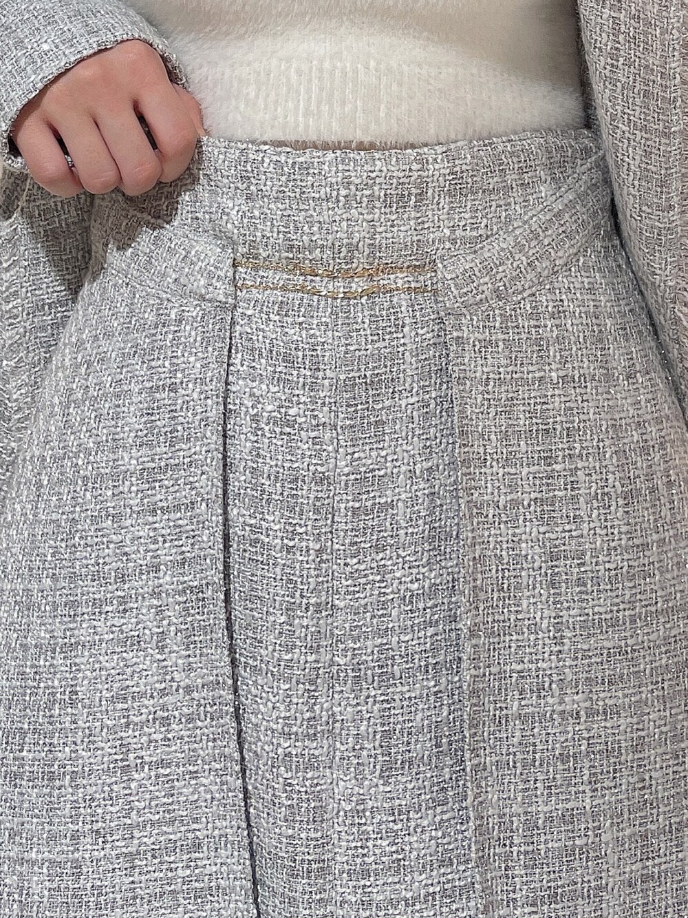 グレー系のテーラードジャケット、グレー系のスカート、ホワイト系のニット/セーターを着用したレディースの秋コーディネートの6枚目の写真