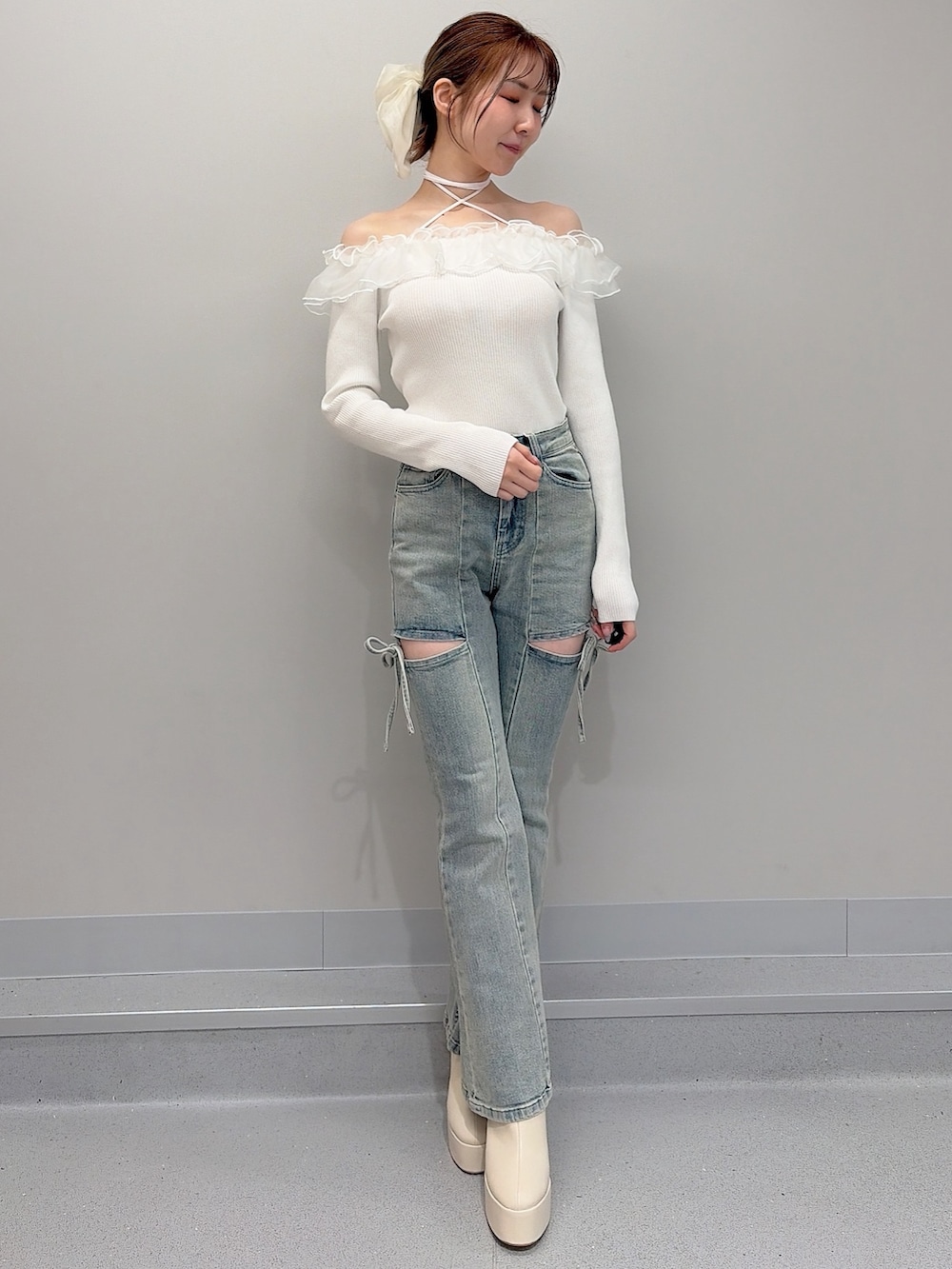 ピンク系のテーラードジャケット、ホワイト系のニット/セーター、ブルー系のデニムパンツを着用したレディースの冬コーディネートの4枚目の写真