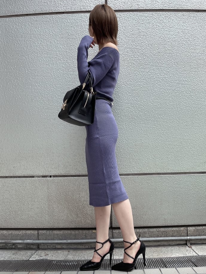 ブラック系のライダースジャケット、ブラック系のハンドバッグ、ブルー系のワンピースを着用したレディースの秋コーディネートの3枚目の写真