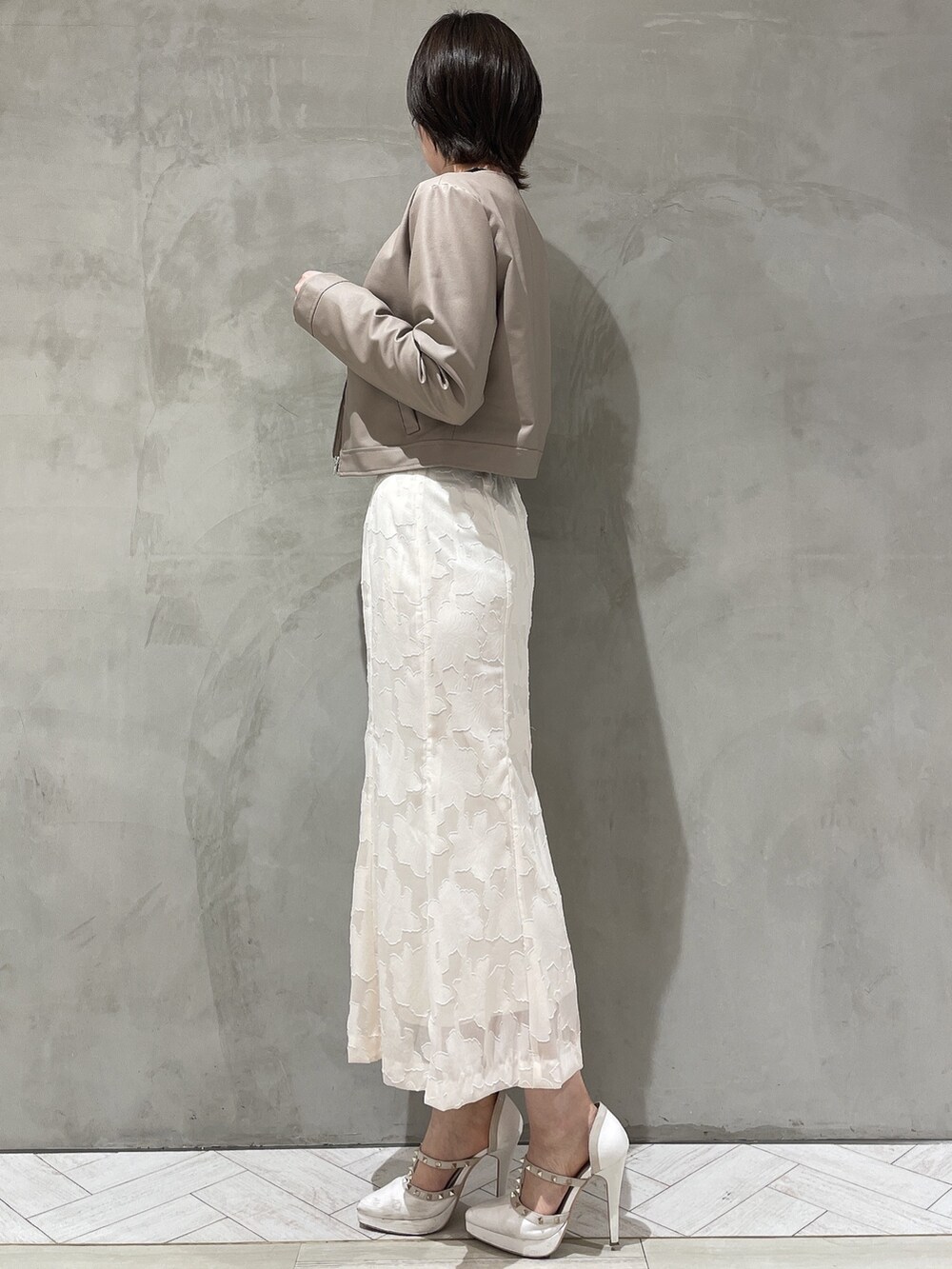 ホワイト系のパンプス、ホワイト系のスカート、ブラック系のニット/セーターを着用したレディースの冬コーディネートの5枚目の写真