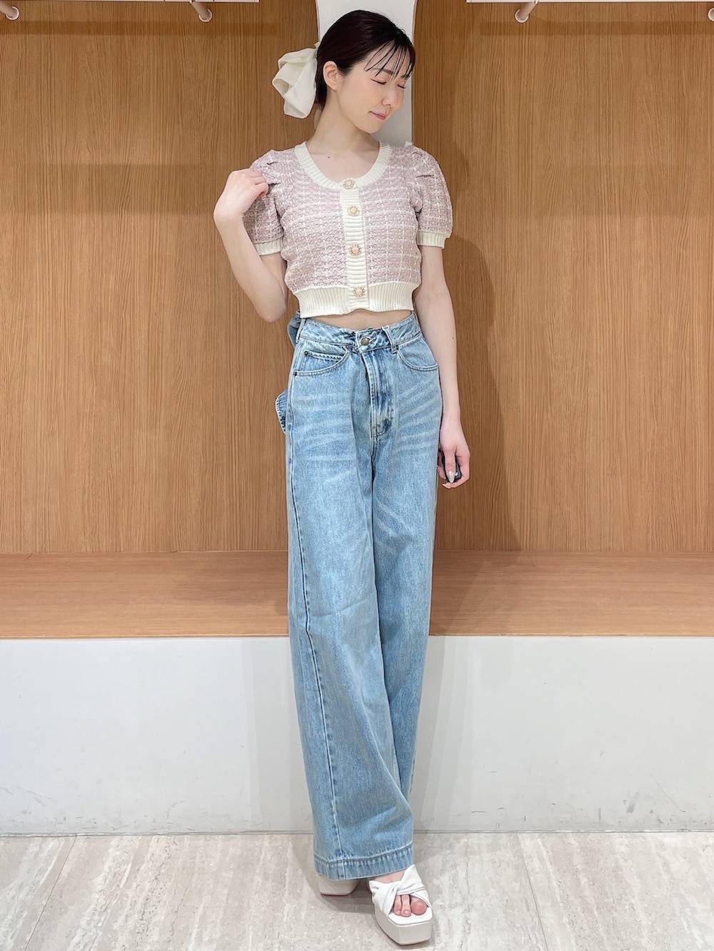 ピンク系のニット/セーター、ブルー系のデニムパンツ、ホワイト系のサンダルを着用したレディースの春コーディネートの2枚目の写真