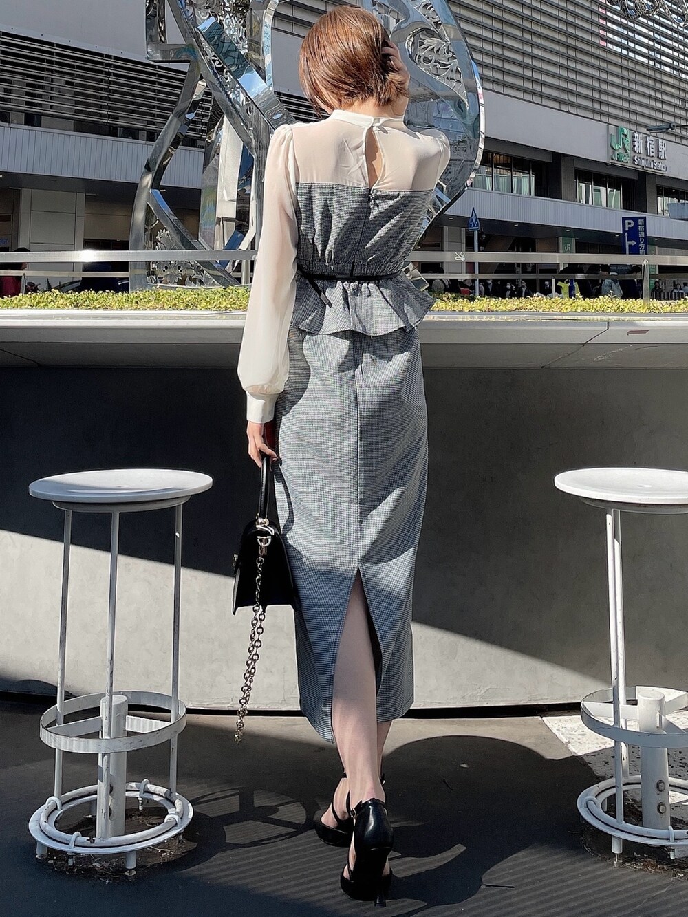 その他のワンピース、ブラック系のハンドバッグ、ブラック系のパンプスを着用したレディースの冬コーディネートの6枚目の写真