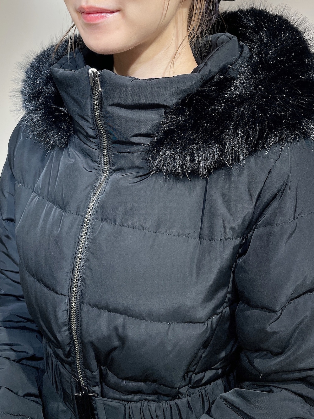 ブラック系のダウンジャケット/コート、ブラック系のワンピース、ブラック系のブーツを着用したレディースの秋コーディネートの5枚目の写真