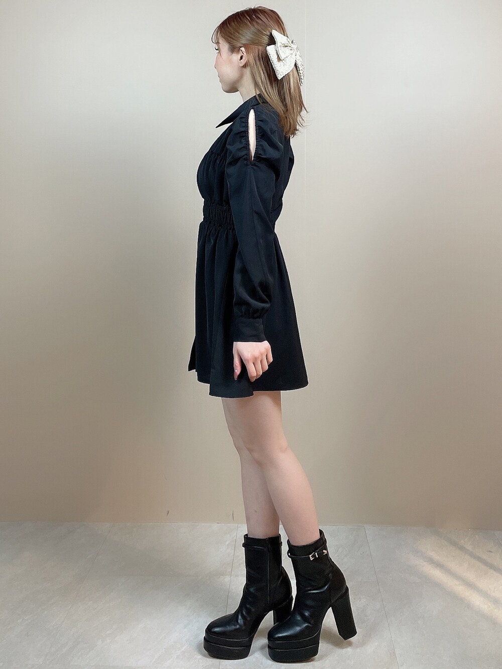 ブラック系のワンピース、ブラック系のブーツ、ベージュ系のバレッタ/ヘアクリップを着用したレディースの冬コーディネートの4枚目の写真