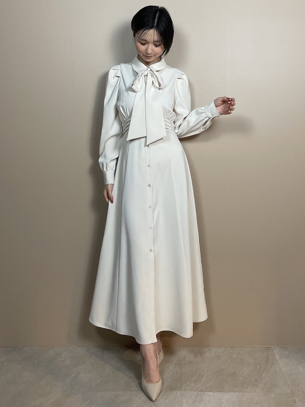 ホワイト系のシャツワンピース、ベージュ系のサンダルを着用したレディースの夏コーディネートの3枚目の写真