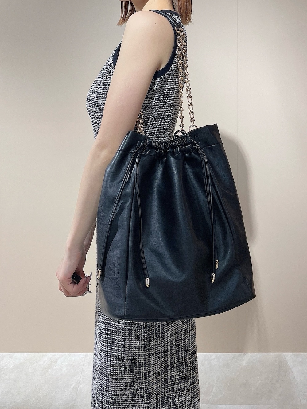 ブラック系のワンピース、ブラック系のトートバッグを着用したレディースの夏コーディネートの7枚目の写真