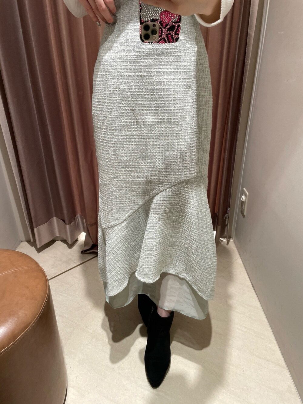 ホワイト系のニット/セーター、グリーン系のスカート、ブラック系のブーツを着用したレディースの冬コーディネートの5枚目の写真