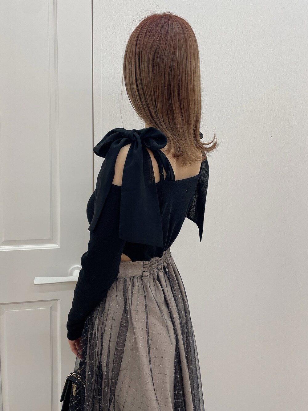 ブラック系のワンピース、ブラック系のハンドバッグ、ブラック系のパンプスを着用したレディースの冬コーディネートの6枚目の写真