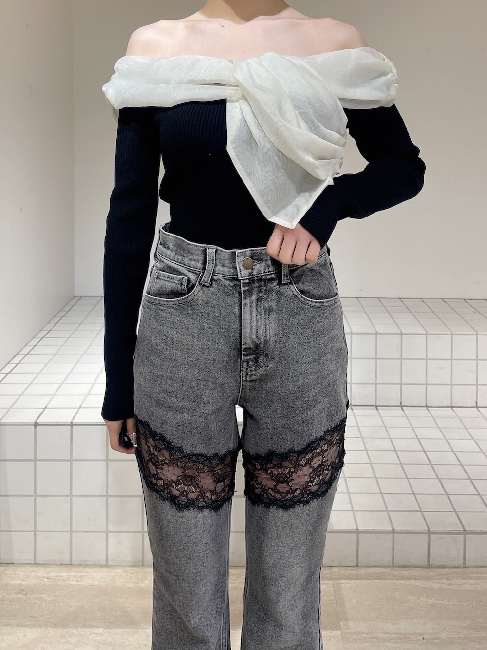 ブラック系のニット/セーター、グレー系のデニムパンツ、ブラック系のブーツを着用したレディースの春コーディネートの5枚目の写真