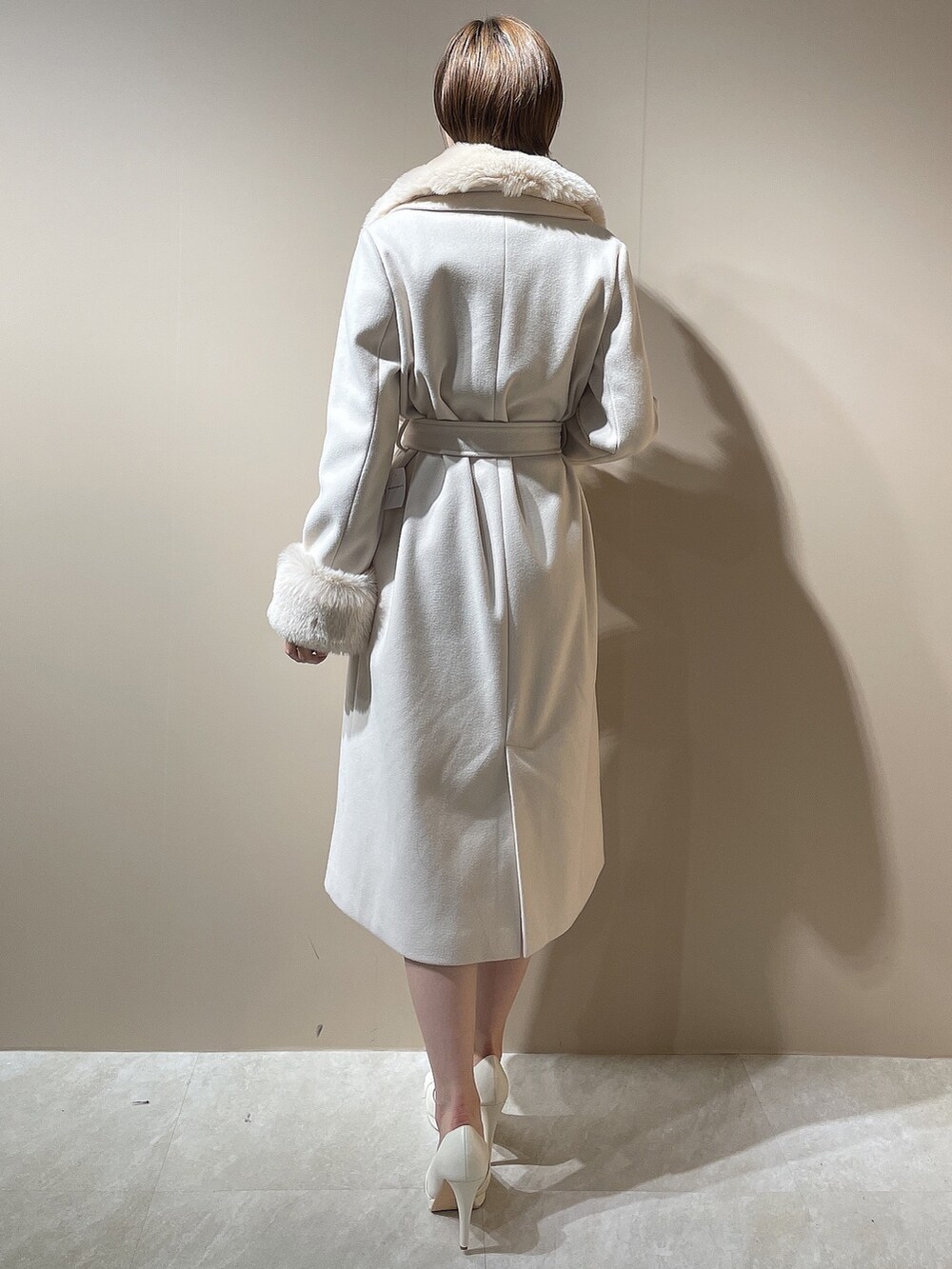 グレー系のワンピース、ホワイト系のパンプス、ホワイト系のチェスターコートを着用したレディースの秋コーディネートの5枚目の写真