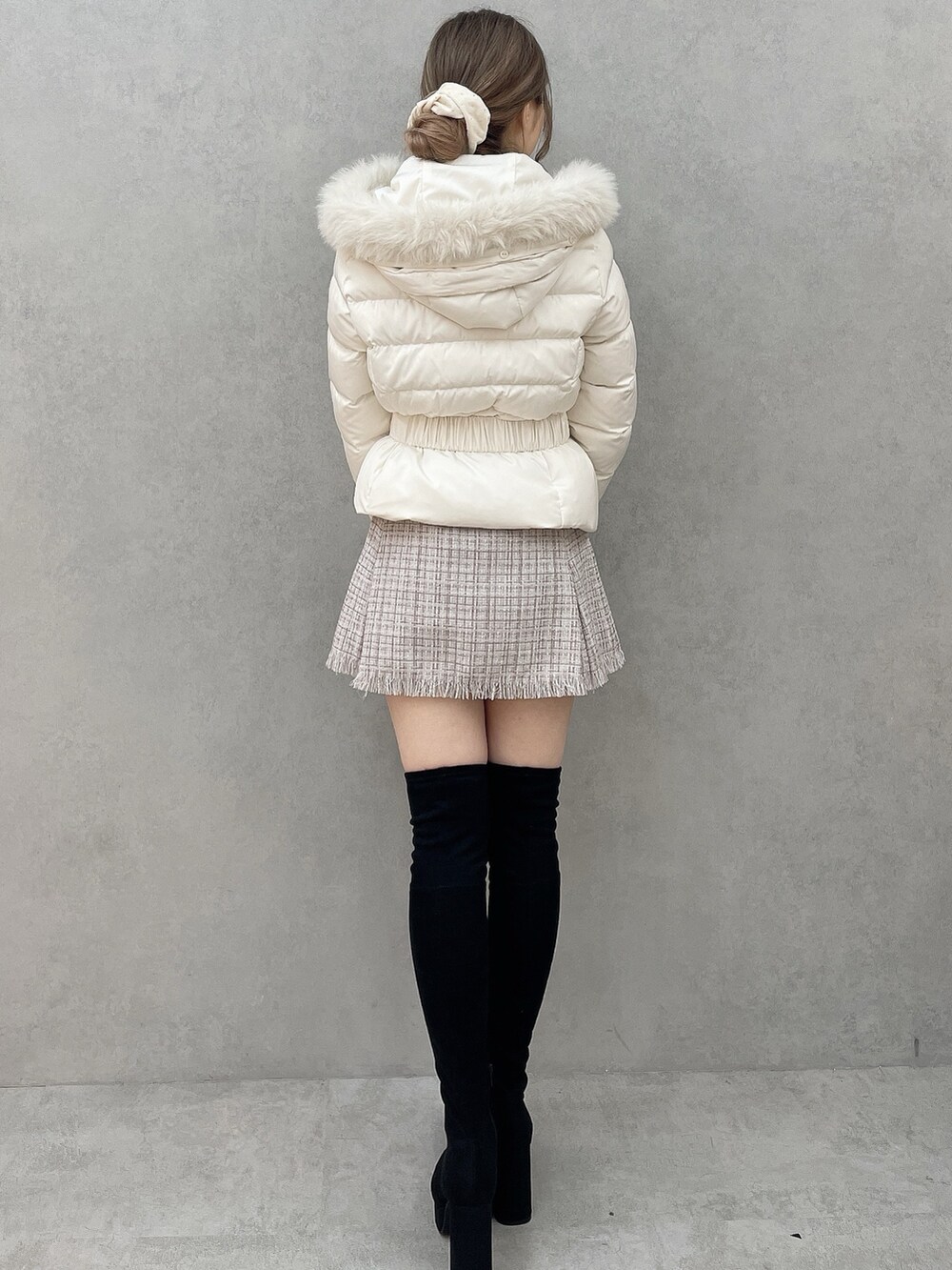 ホワイト系のダウンジャケット/コート、パープル系のスカート、ブラック系のブーツを着用したレディースの秋コーディネートの4枚目の写真