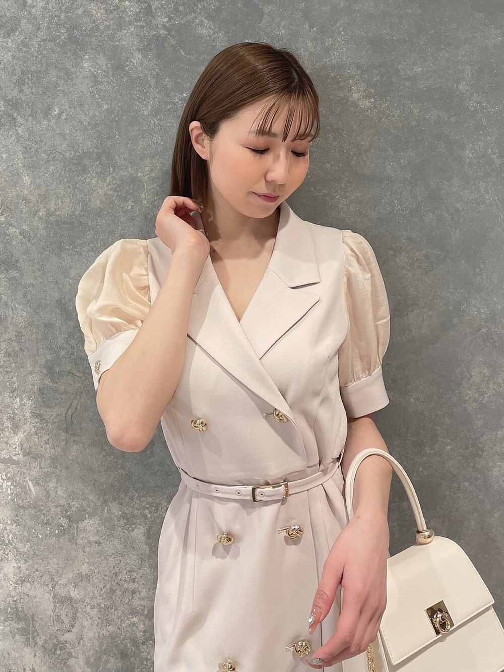 ホワイト系のワンピース、ホワイト系のハンドバッグ、ホワイト系のサンダルを着用したレディースの春コーディネートの5枚目の写真