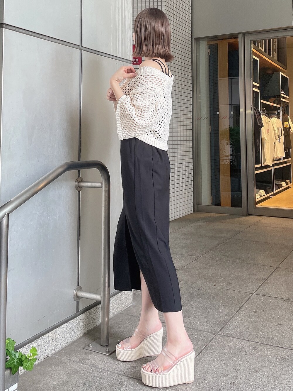 ホワイト系のカーディガン/ボレロ、ブラック系のワンピース、ホワイト系のサンダルを着用したレディースの夏コーディネートの5枚目の写真