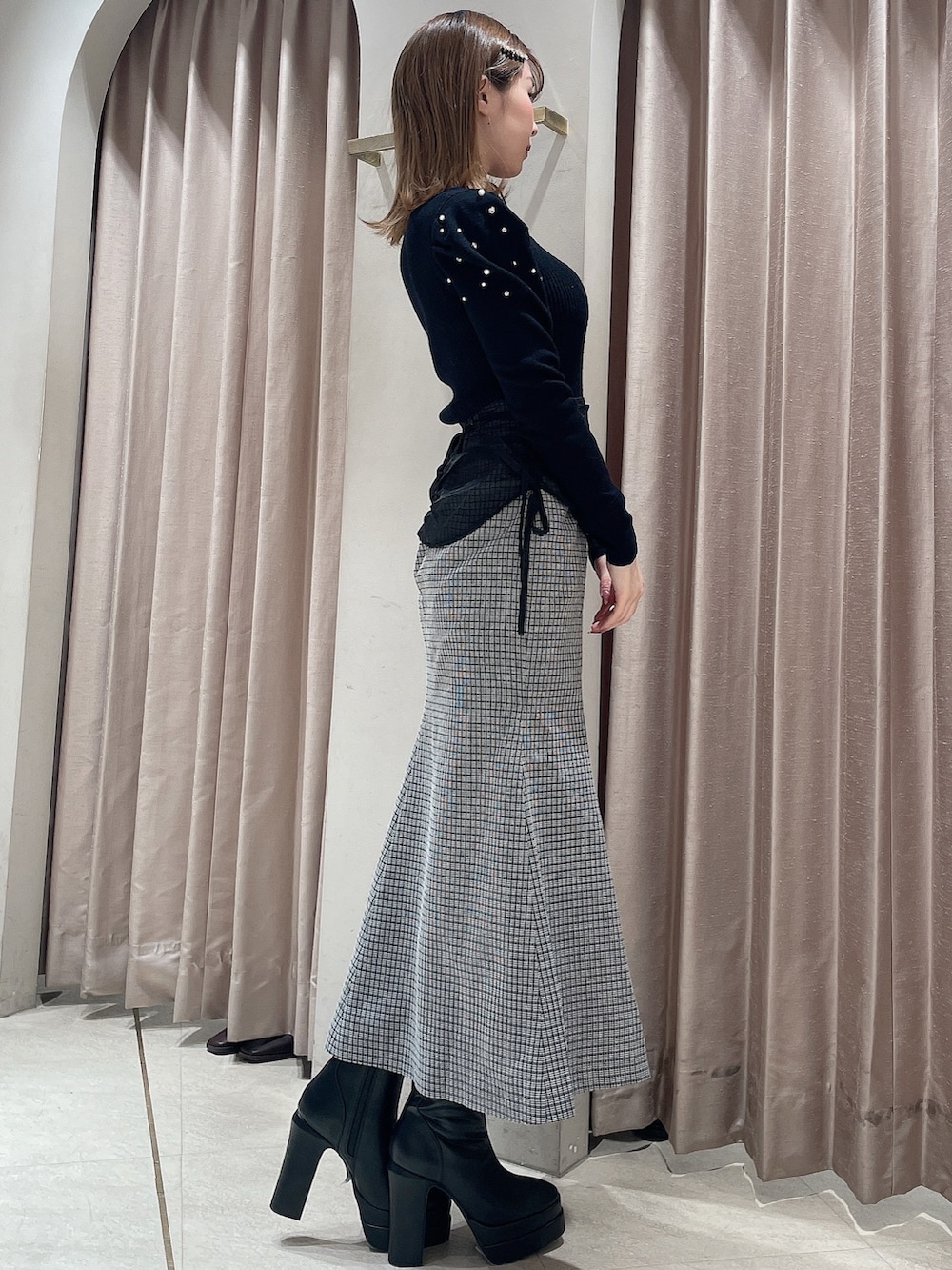 ブラック系のニット/セーター、その他のスカート、ブラック系のブーツを着用したレディースの冬コーディネートの2枚目の写真