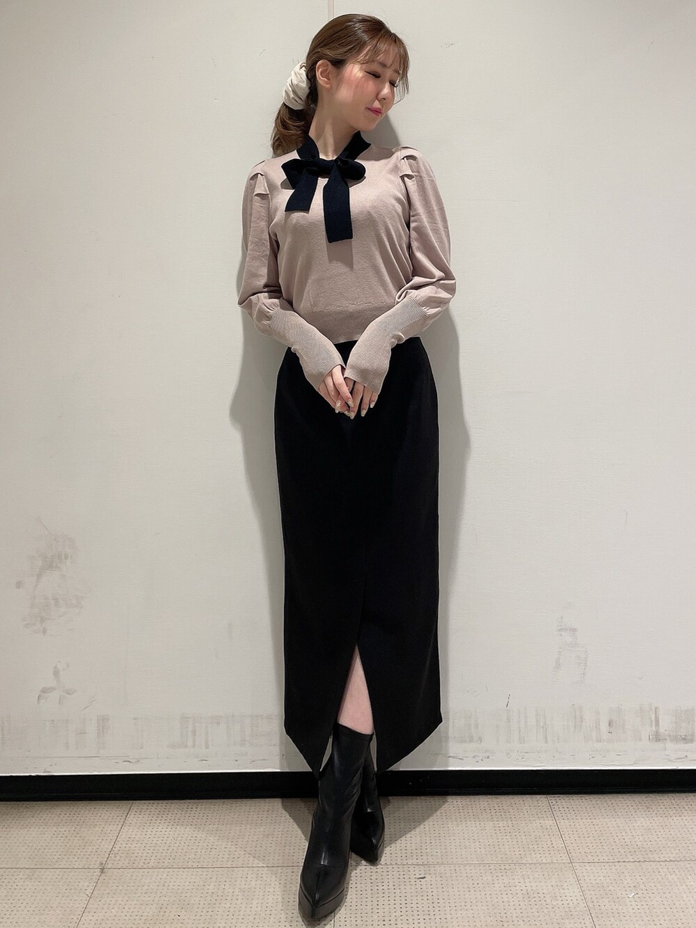 ベージュ系のニット/セーター、ブラック系のスカート、ブラック系のブーツを着用したレディースの冬コーディネートの2枚目の写真