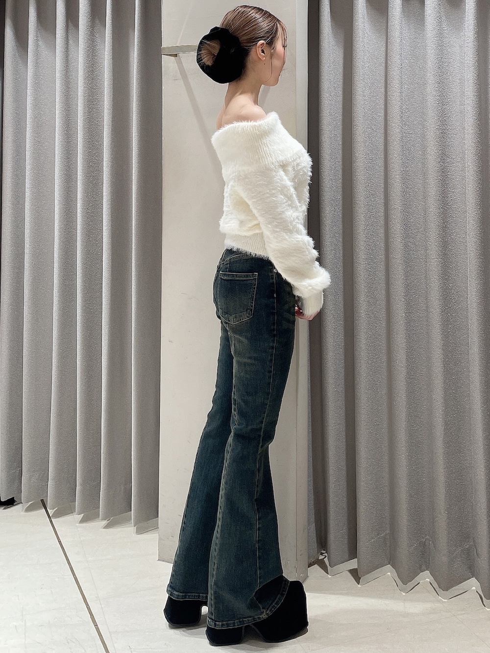 ホワイト系のニット/セーター、ブルー系のデニムパンツ、ブラック系のブーツを着用したレディースの秋コーディネートの3枚目の写真
