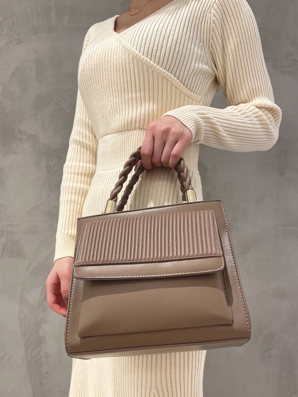 ホワイト系のワンピース、ホワイト系のパンプス、ブラウン系のハンドバッグを着用したレディースの秋コーディネートの6枚目の写真